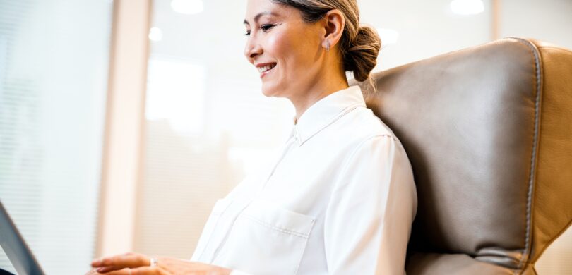 An older woman sits at a computer.